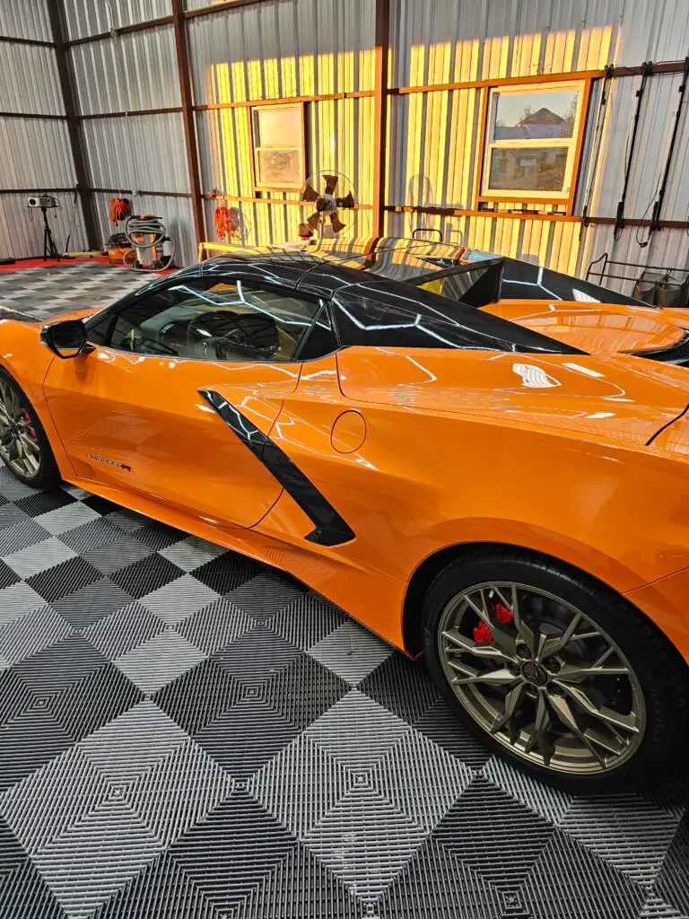 Pristine orange sports car in a detailing garage after receiving a ceramic coating, showcasing the vehicle's enhanced shine and long-lasting protection from Fort Worth Auto Detail.
